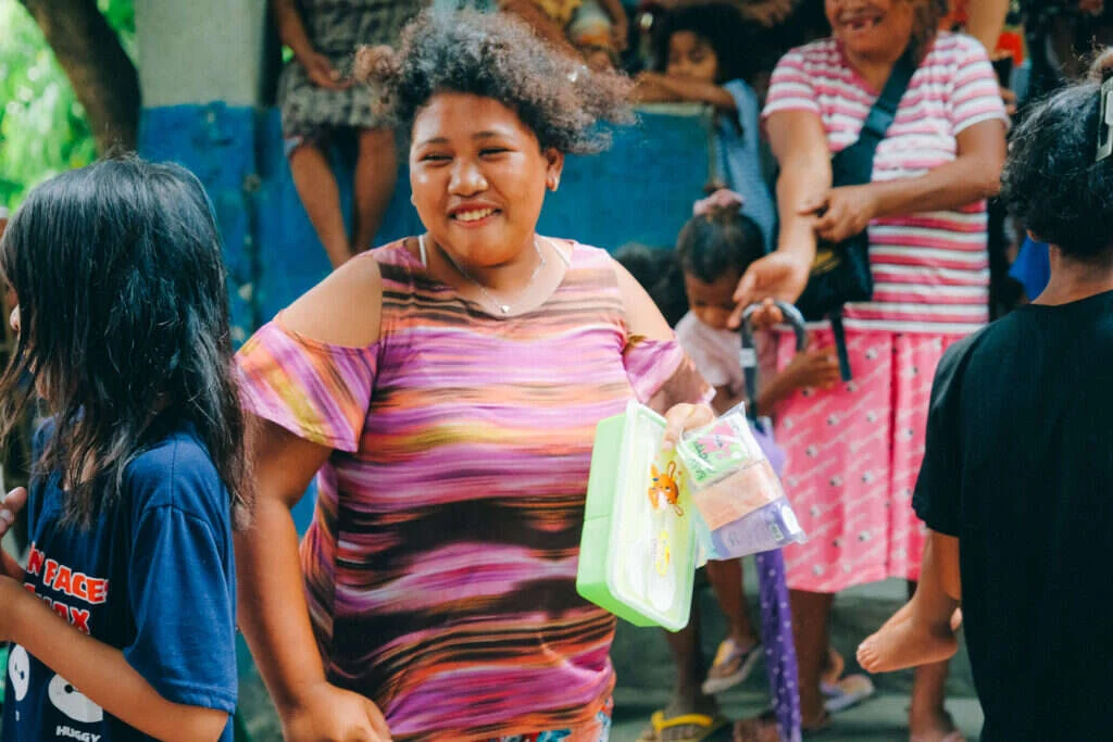 A woman smiling as she receives a package