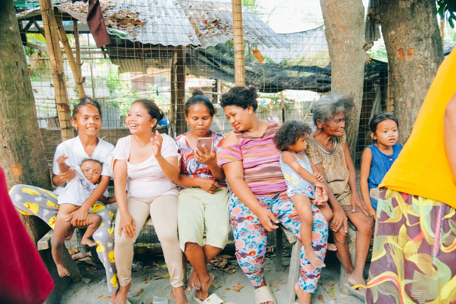 Mothers and grandmothers laughing together on a bench