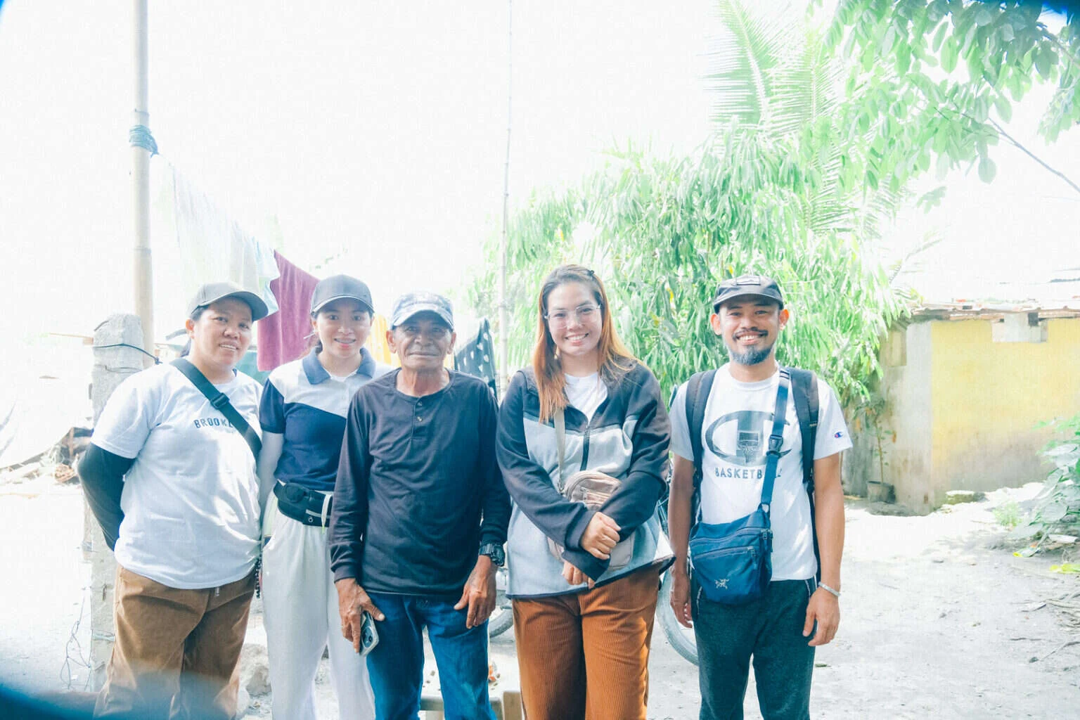 The His Word outreach team standing together on the road out of the community