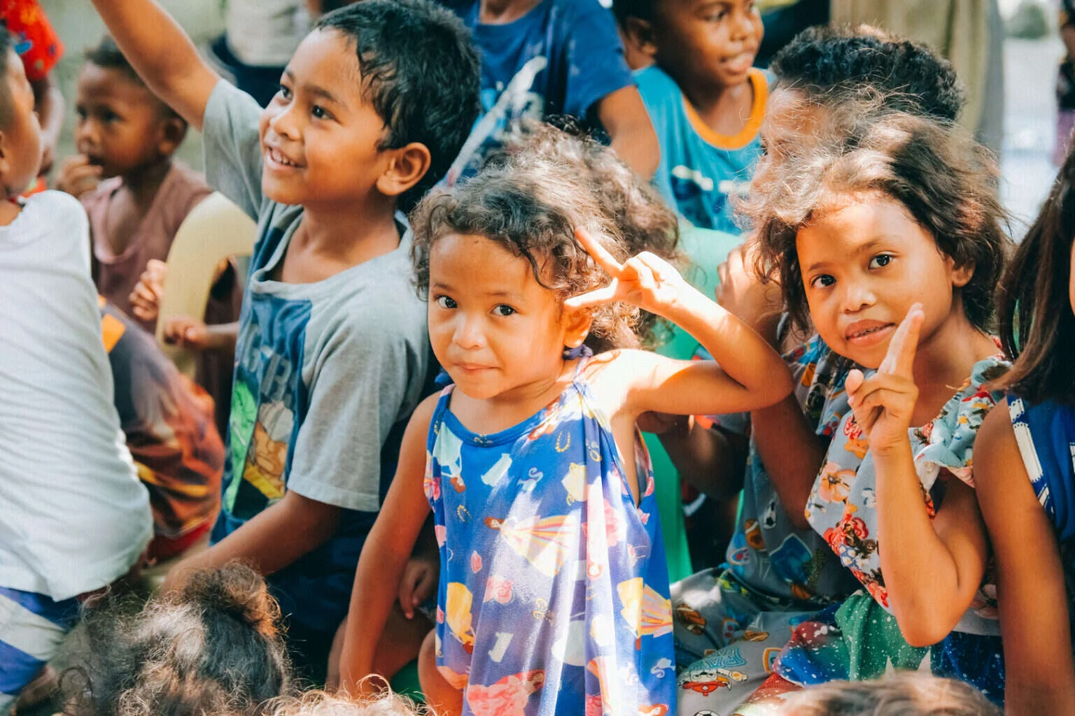 Children in a Pampanga community waving and smiling at the camera during a His Word outreach visit